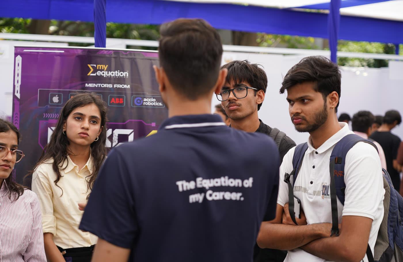 A My Equation mentor talking with students at an event