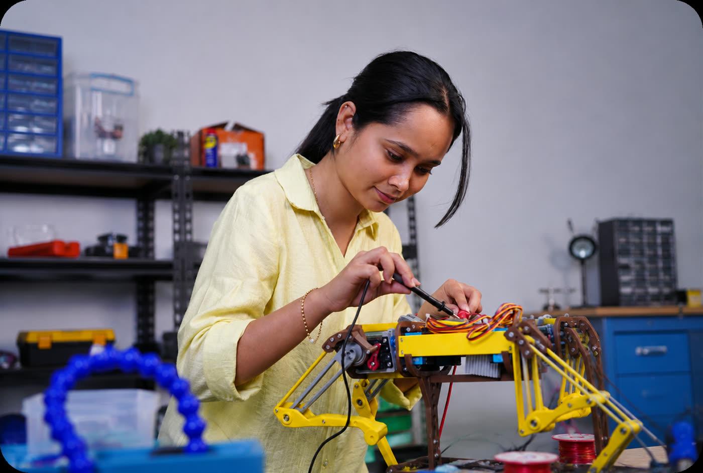A learner soldering a robot at the lab