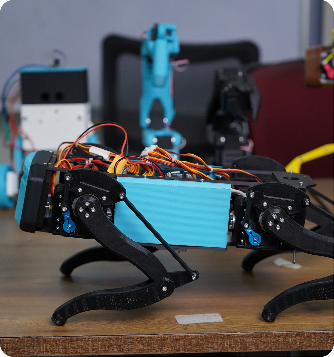 Quadruped robot with a blue chassis on a workbench