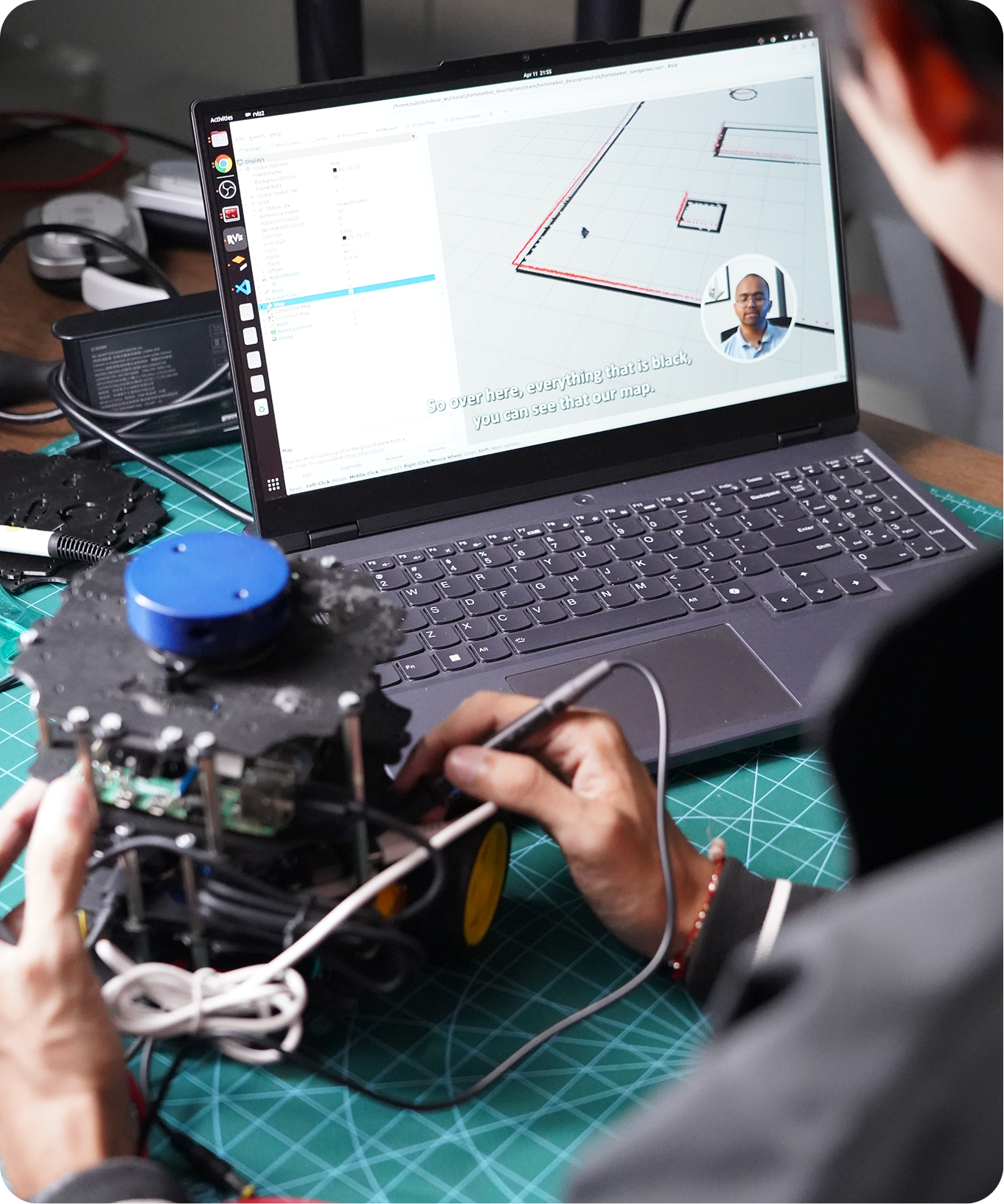 Student mapping a robot's navigation using RViz on a laptop