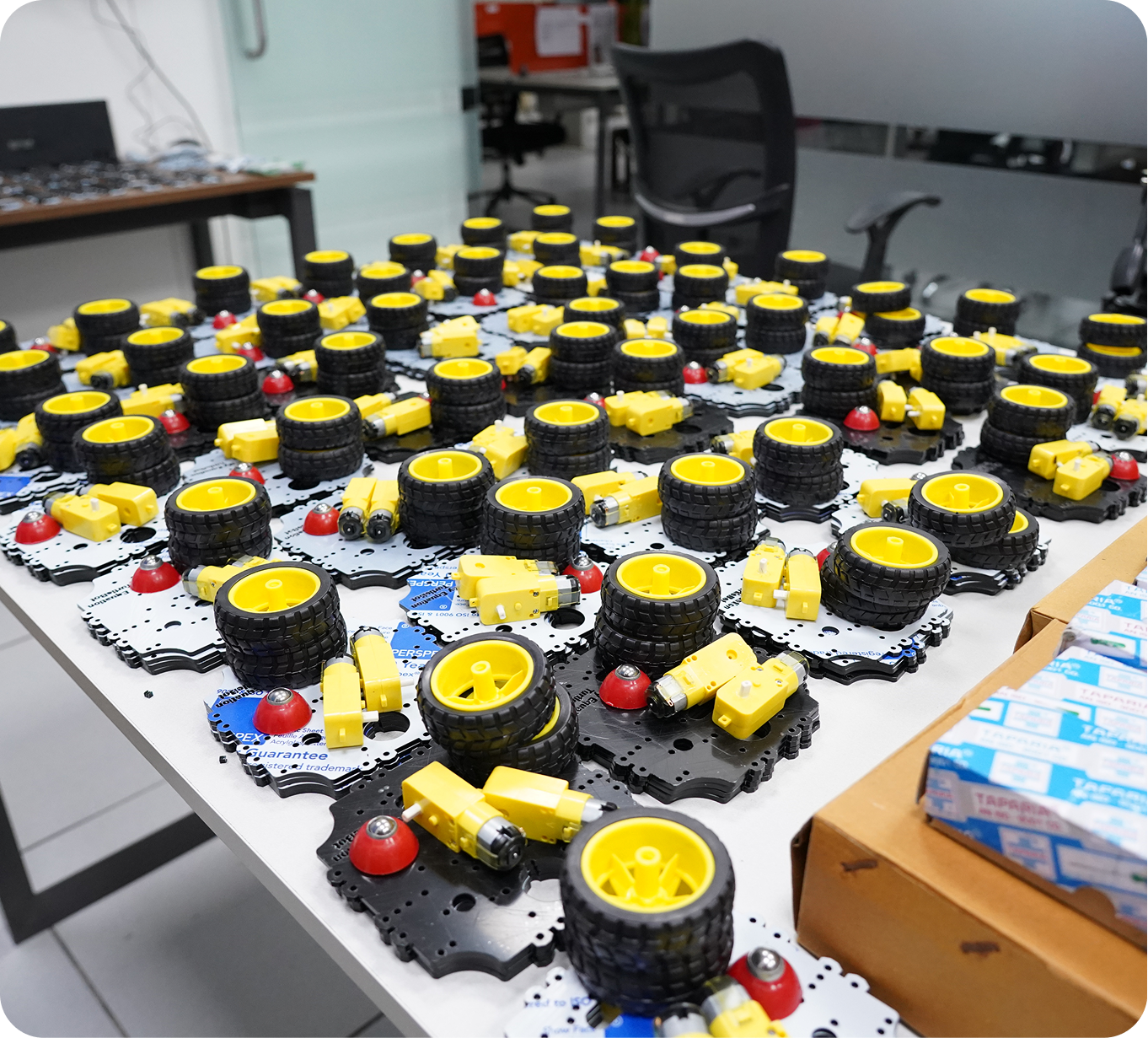 Table full of robot wheel and motor assemblies