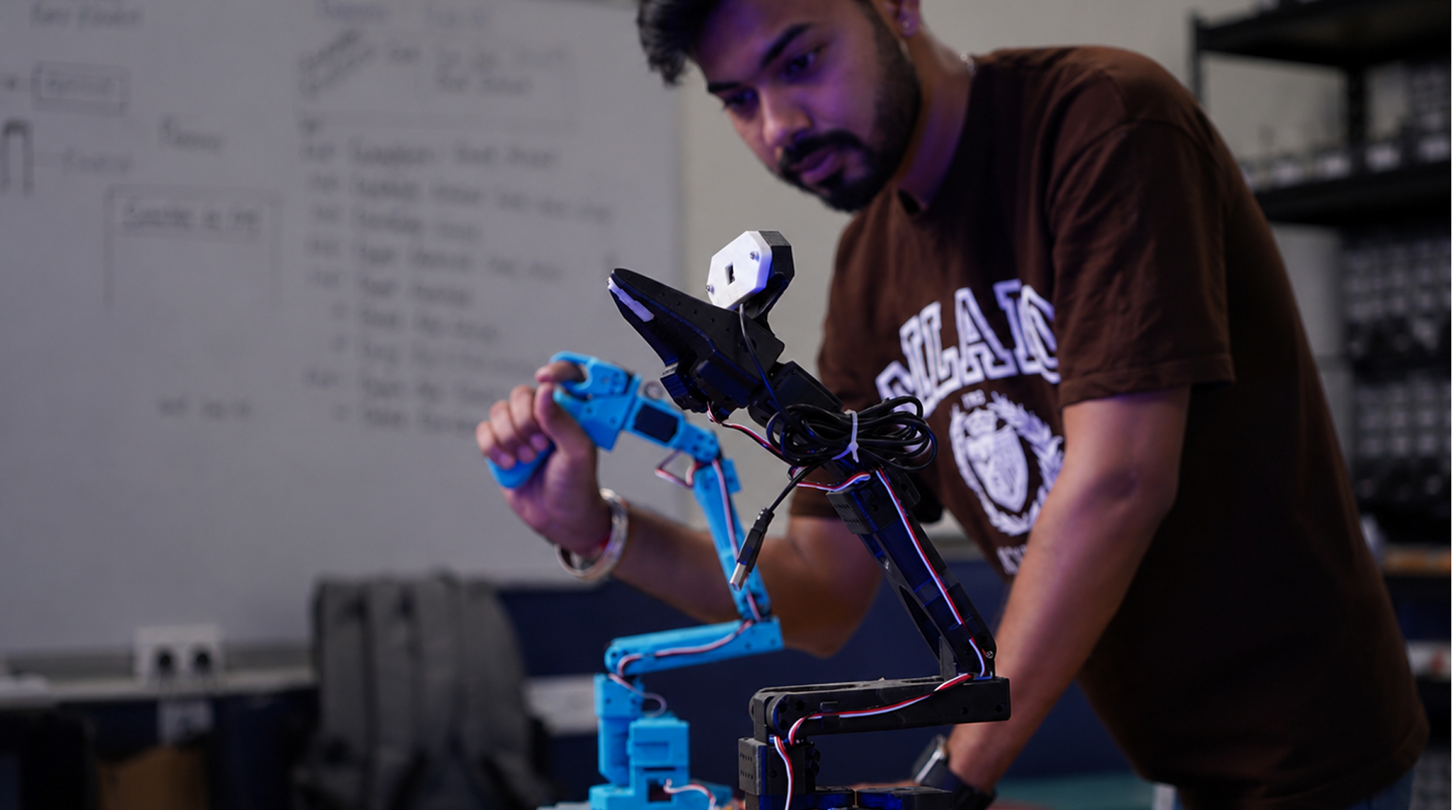 Student working on a robotics arm in the lab