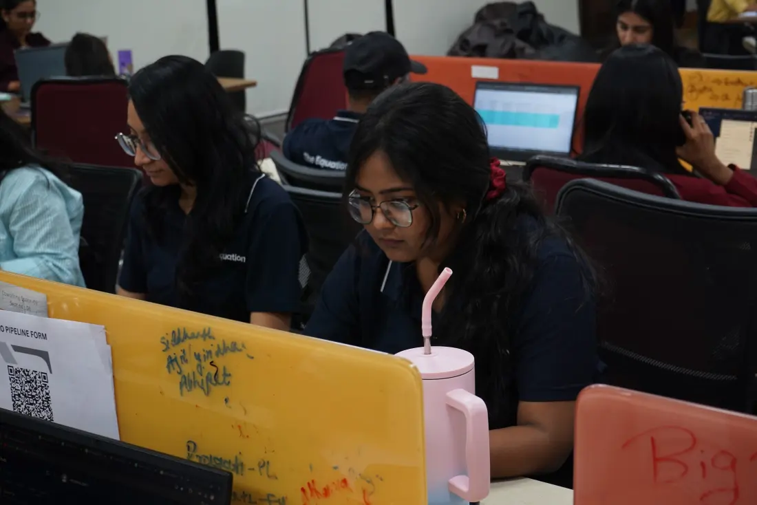 Two professionals working at laptops in the My Equation office
