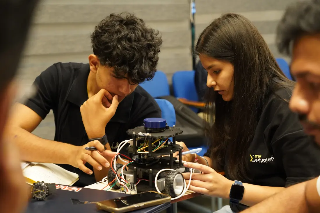 Two learners wiring a robot kit together