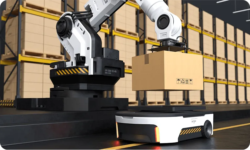 An autonomous mobile robot carrying a carton down a warehouse aisle beside a robotic arm
